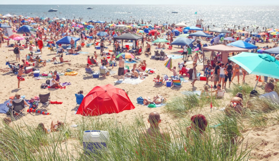 Melhor época para visitar Prado Bahia – praia de Guaratiba com mar calmo e poucas pessoas na baixa temporada versus movimento na alta temporada, ilustrando a diferença de movimento no destino ideal para apartamento para aluguel de temporada